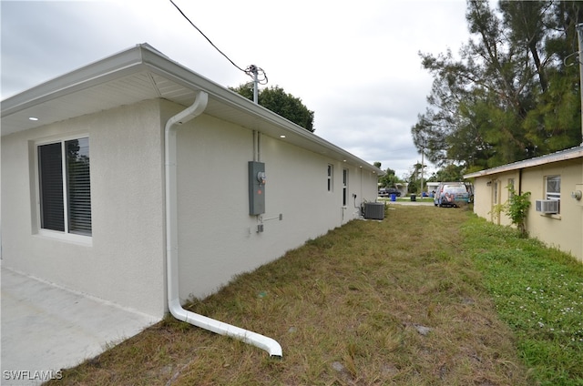 view of side of home featuring central AC, a yard, and cooling unit