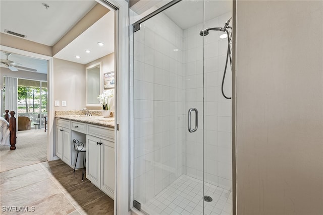 bathroom featuring vanity, an enclosed shower, and ceiling fan