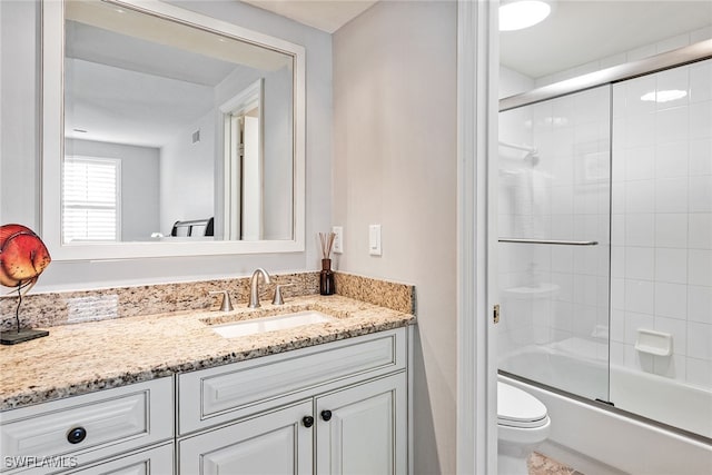 full bathroom with shower / bath combination with glass door, vanity, and toilet