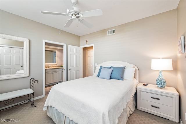 carpeted bedroom featuring ensuite bath, ceiling fan, and sink