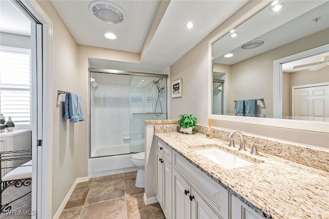 full bathroom featuring ceiling fan, vanity, bath / shower combo with glass door, and toilet