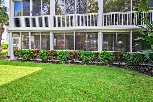 rear view of property featuring a lawn