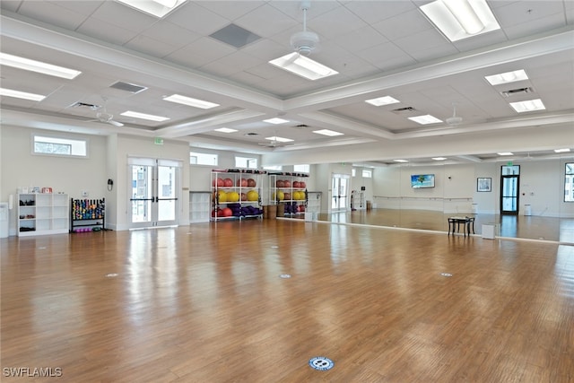 workout area with french doors and light hardwood / wood-style floors