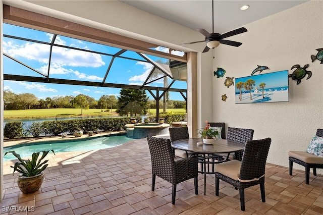 view of patio with a pool with hot tub, ceiling fan, a lanai, and a water view