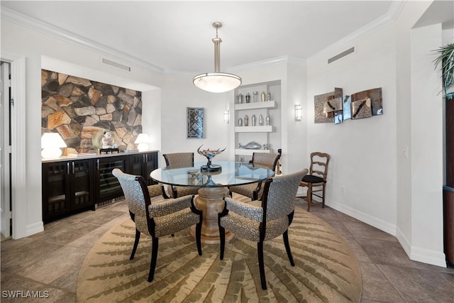 dining room featuring bar, built in features, beverage cooler, and ornamental molding