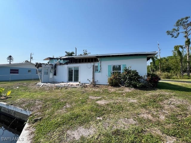 rear view of property featuring a yard