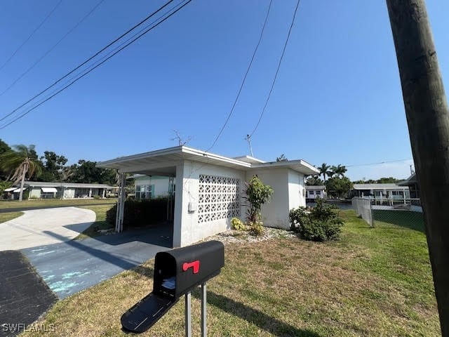 view of home's exterior with a lawn and a carport