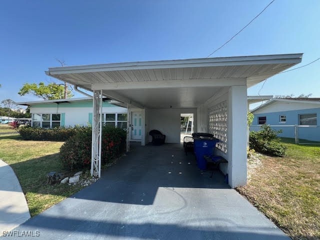 view of vehicle parking featuring a carport and a yard