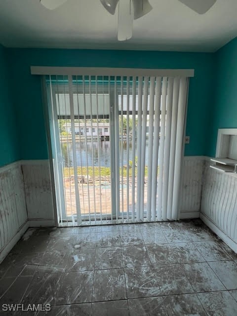 spare room with a water view and ceiling fan