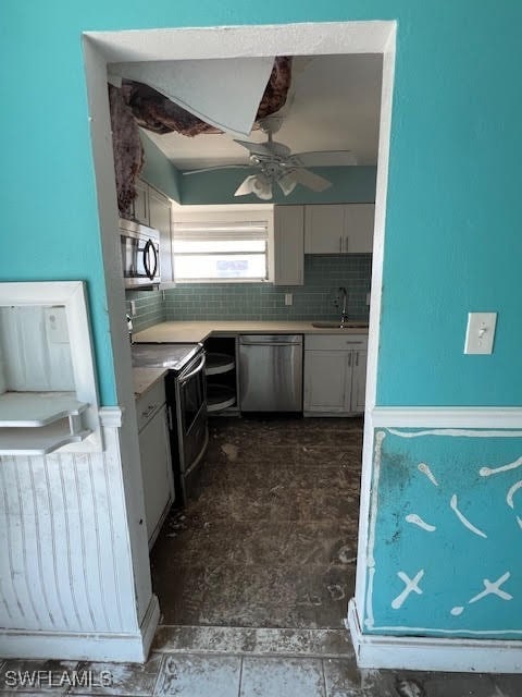 kitchen featuring decorative backsplash, ceiling fan, sink, and appliances with stainless steel finishes