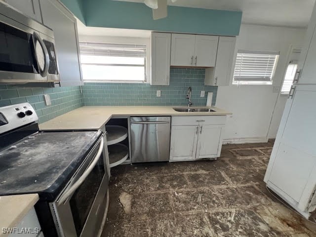 kitchen featuring white cabinetry, sink, ceiling fan, stainless steel appliances, and tasteful backsplash