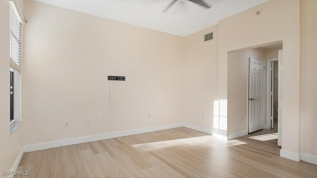 empty room featuring visible vents, baseboards, and light wood-style flooring