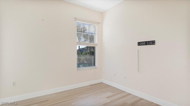 unfurnished room featuring light wood-type flooring and baseboards