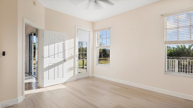 spare room featuring a ceiling fan, wood finished floors, and baseboards