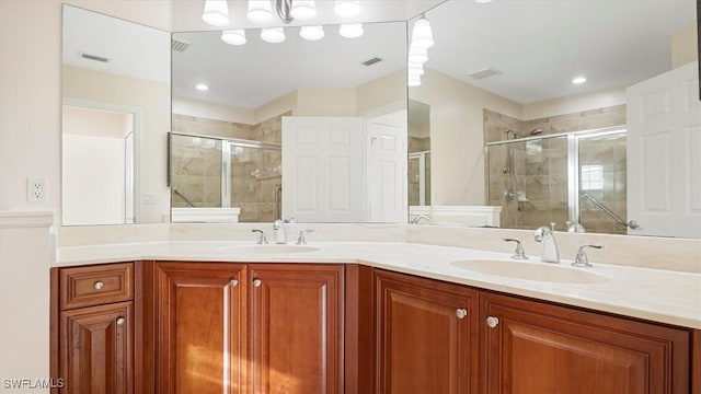 bathroom with a sink, visible vents, a stall shower, and double vanity