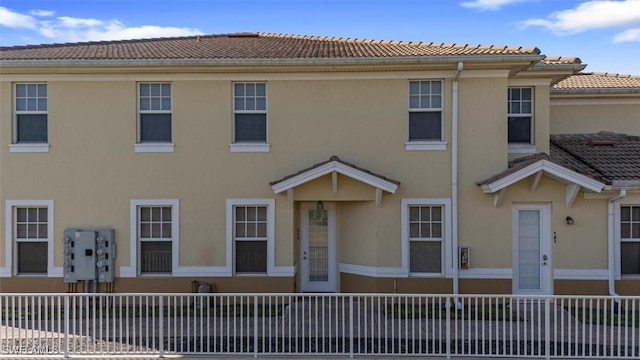 multi unit property featuring a tiled roof and stucco siding