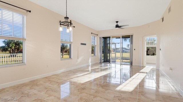 spare room featuring visible vents, baseboards, marble finish floor, and ceiling fan with notable chandelier