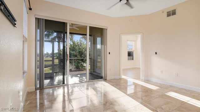 unfurnished room with visible vents, marble finish floor, a ceiling fan, arched walkways, and baseboards