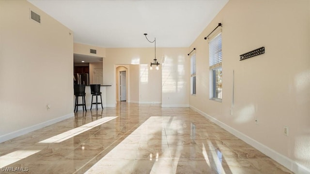 unfurnished room with visible vents, marble finish floor, and baseboards