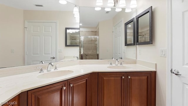 full bath with a shower stall, double vanity, visible vents, and a sink