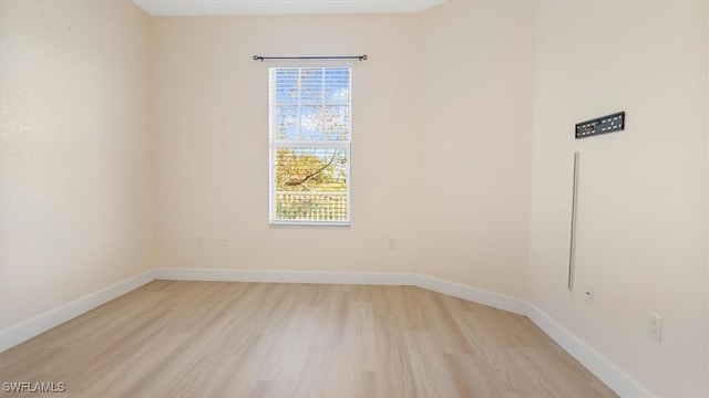 empty room with baseboards and light wood finished floors