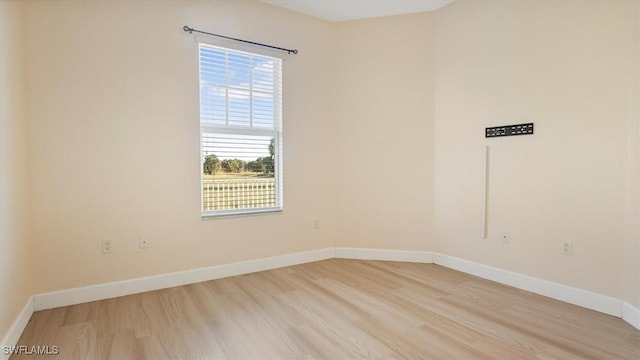 spare room with light wood-type flooring and baseboards