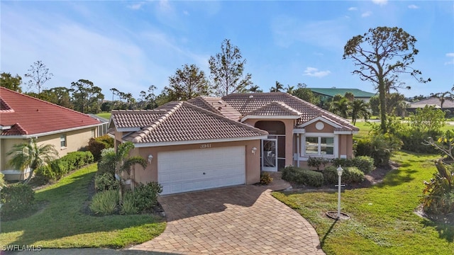 mediterranean / spanish home with a front lawn and a garage