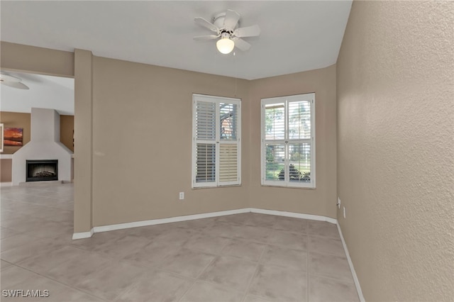 empty room featuring ceiling fan and a fireplace