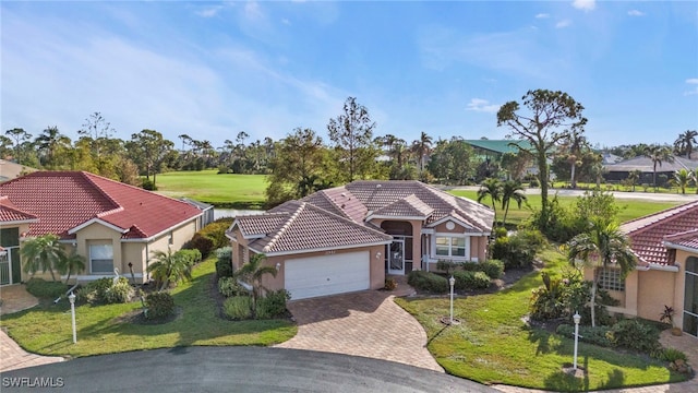 mediterranean / spanish-style home with a garage and a front lawn