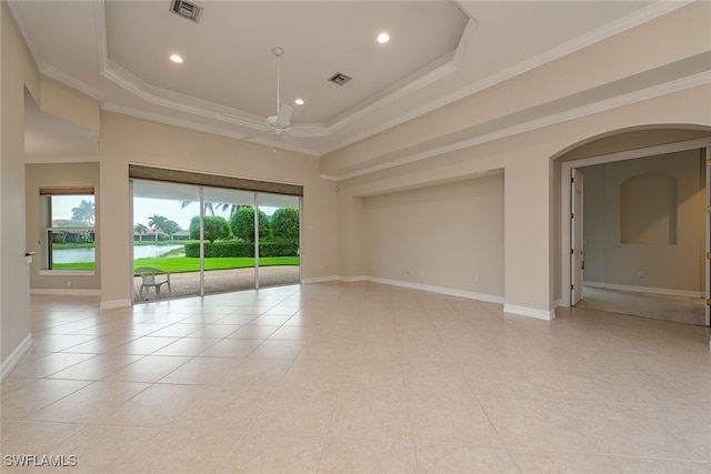 unfurnished room with ornamental molding, a tray ceiling, ceiling fan, a water view, and light tile patterned flooring