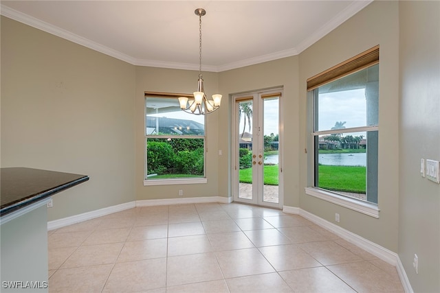 unfurnished dining area featuring plenty of natural light, a water view, an inviting chandelier, and ornamental molding