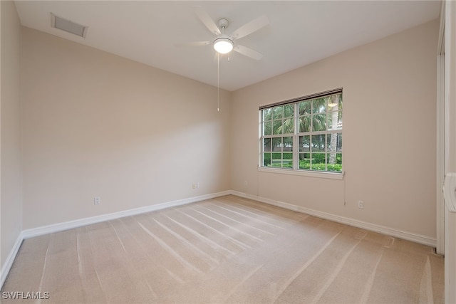 spare room featuring light colored carpet and ceiling fan