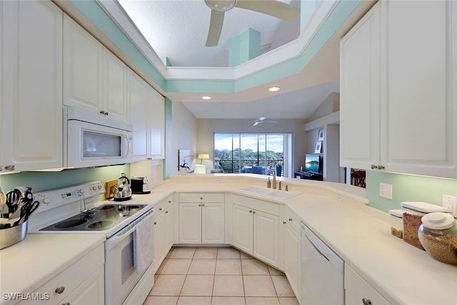 kitchen with sink, light tile patterned floors, vaulted ceiling, white appliances, and white cabinets