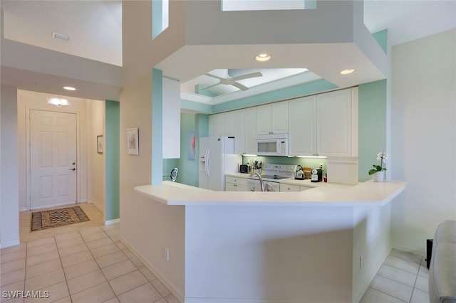 kitchen featuring kitchen peninsula, white cabinetry, light tile patterned flooring, and white appliances