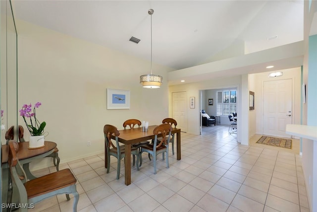 dining room with light tile patterned floors and high vaulted ceiling