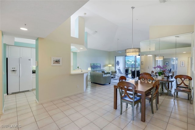 tiled dining space featuring high vaulted ceiling