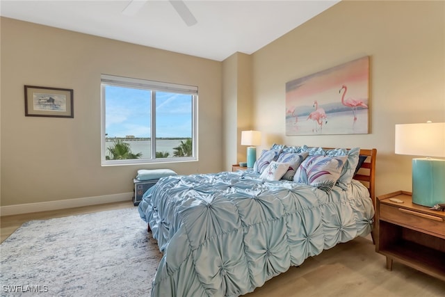 bedroom with wood finished floors, a ceiling fan, and baseboards