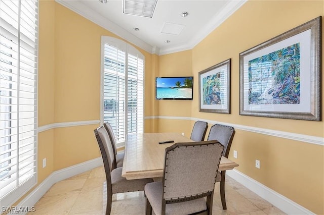 dining room with baseboards and crown molding