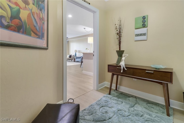 corridor with baseboards and wood finished floors