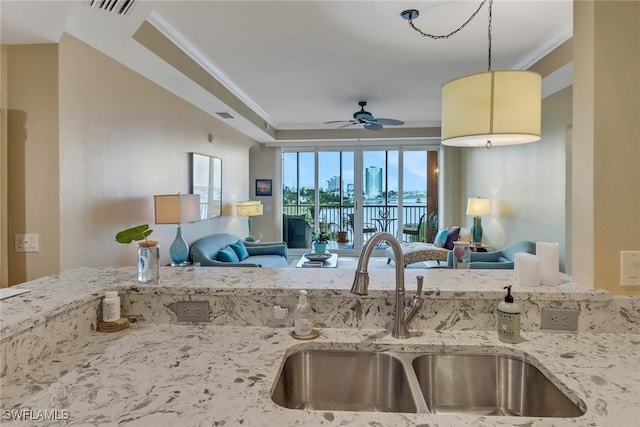 kitchen featuring crown molding, open floor plan, and a sink