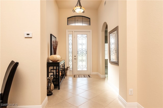 foyer with light tile patterned floors and a high ceiling