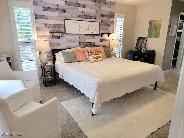 carpeted bedroom with wood walls and multiple windows