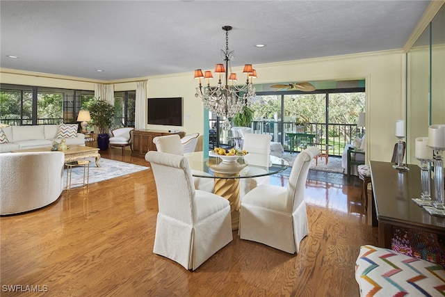 dining area featuring hardwood / wood-style flooring, crown molding, and an inviting chandelier