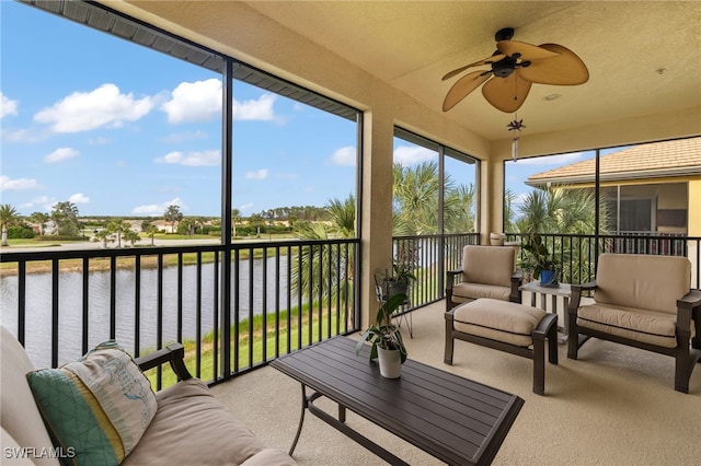 sunroom featuring a water view and a ceiling fan