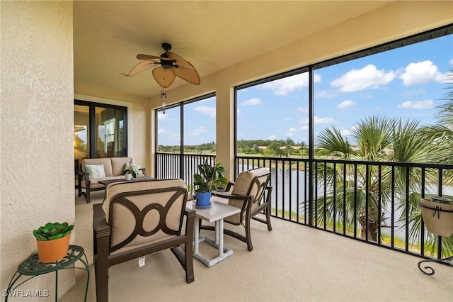 sunroom / solarium with a water view and ceiling fan