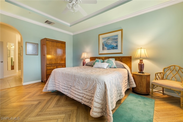 bedroom featuring ceiling fan, crown molding, light parquet flooring, and ensuite bath