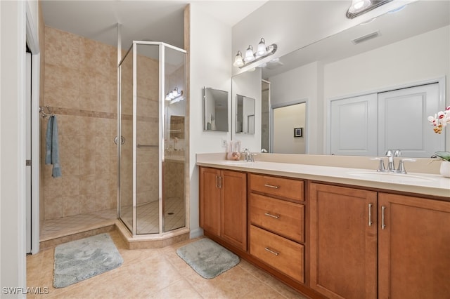 bathroom with tile patterned flooring, vanity, and a shower with shower door