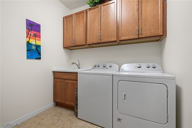 washroom featuring washer and clothes dryer, cabinets, light tile patterned floors, and sink