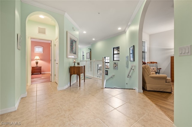 corridor with light tile patterned floors, a wealth of natural light, and ornamental molding