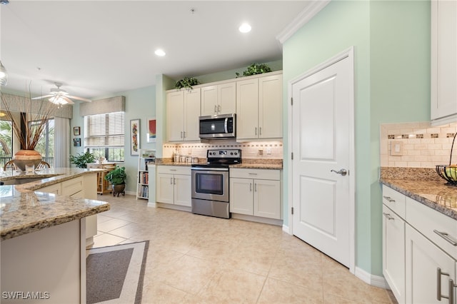 kitchen featuring ceiling fan, light stone countertops, stainless steel appliances, backsplash, and white cabinets